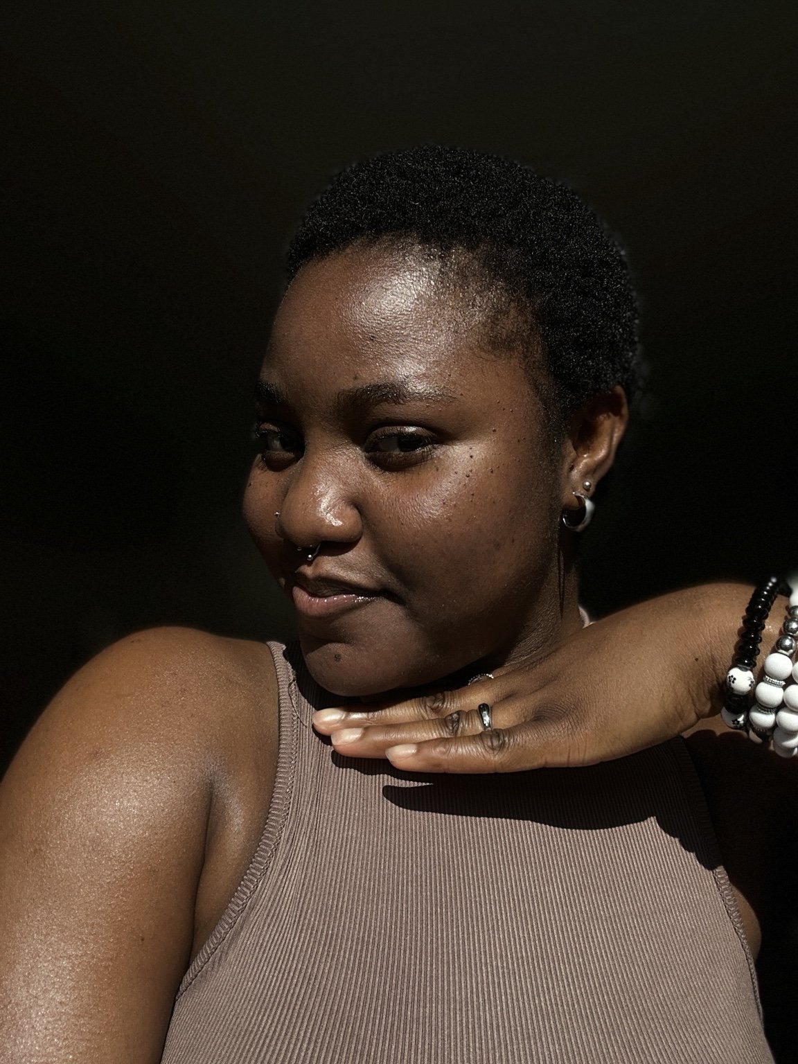 Temi smiling with her hand beneath her chin